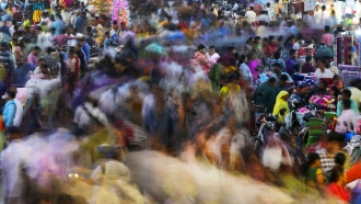 People move through a market in Mumbai, India