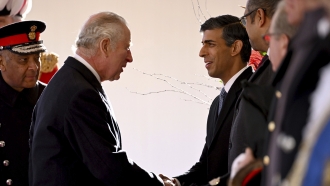 Britain's King Charles III of the United Kingdom shakes hands with British Prime Minister Rishi Sunak.