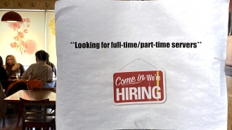 A hiring sign is displayed at a restaurant in Morton Grove, Illinois.