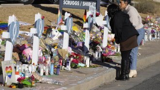 Mourners stand along a makeshift memorial in Colorado Springs