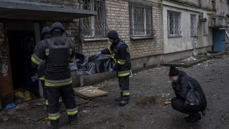 City responders collect the body of a resident killed by Russian bombardment in Kherson.