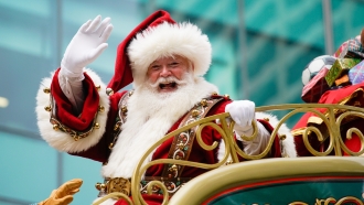 Santa Claus waves from atop a float.