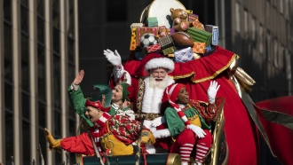 Santa Claus waves from atop a float.