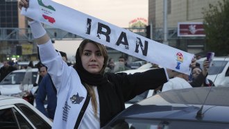 An Iranian woman holds up a World Cup banner