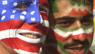 A U.S. soccer fan poses with an Iranian soccer fan.