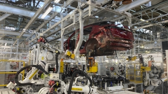 Robotic arms put in the electric vehicle powertrain into the Ariya model in the assembly line at Nissan's Tochigi plant