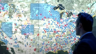 A man looks at a map of Jewish communities and threats to them.
