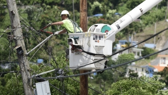 A worker installs power lines in a Puerto Rican town.