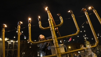 Rabbanit Dasi Fruchter, of the South Philadelphia Shtiebel, lights a menorah during a public Hanukkah celebration