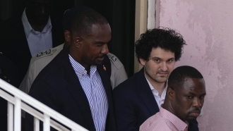 FTX founder Sam Bankman-Fried is escorted out of Magistrate Court in the Bahamas.