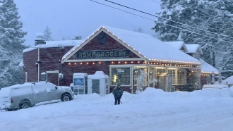A person shovels snow outside Rome Grocery northeast of Bellingham, Washington.