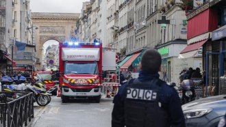A police officer stands next to the cordoned off area where a shooting took place in Paris,