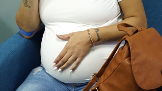 A pregnant woman rubs her stomach