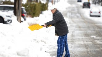 A man shovels snow.