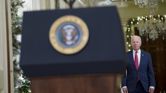 President Joe Biden walks up to a podium.