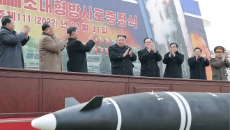 North Korean leader Kim Jong Un, center, attends a ceremony of donating 600mm super-large multiple launch rocket system