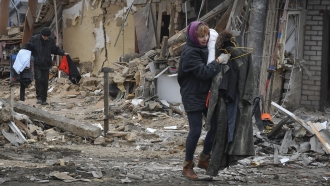 Ukrainians flee homes destroyed by Russian shelling.