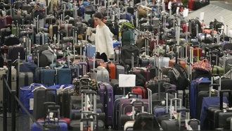 A woman walks through unclaimed bags at Southwest Airlines baggage claim