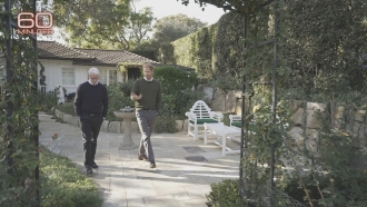 Journalist Anderson Cooper walks with Prince Harry during a "60 Minutes" interview