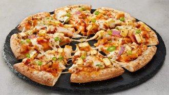 Chicken pizza from Australia with a variety of toppings.
