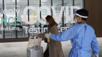 A woman arriving from China enters a COVID-19 testing center in South Korea