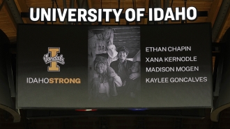 A photo and the names of four University of Idaho students who were killed near campus is displayed before a basketball game.