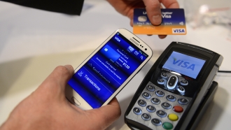 A man uses the NFC payment Visa system at the Mobile World Congress