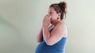 Pregnant woman wiping her nose.