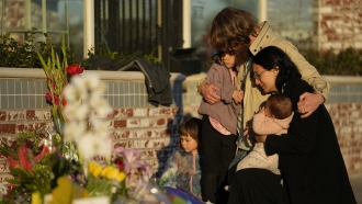 A family gathers at a memorial outside the Star Ballroom Dance Studio in Monterey Park, California