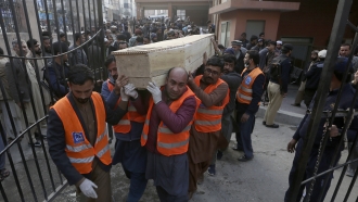 Volunteers carry a coffin of a suicide bombing victim in Pakistan.