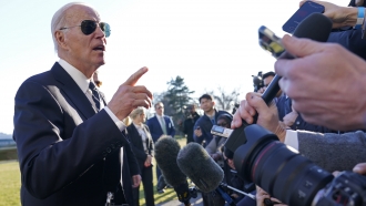 President Joe Biden talks with reporters on the South Lawn of the White House.