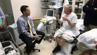 An oncologist speaks with a patient.