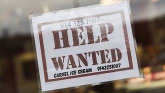 A help wanted sign in a storefront