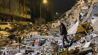 Man searches a collapsed building after an earthquake in southern Turkey.