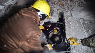 Emergency workers and medics rescue a woman out of the debris of a collapsed building after an earthquake in Turkey..