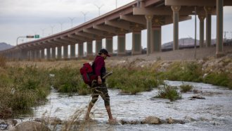 A migrant from Ecuador crosses the Rio Grande toward El Paso, Texas
