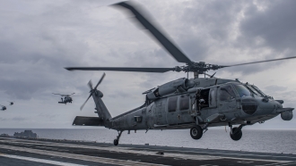 An MH-60S Sea Hawk helicopter lands aboard the aircraft carrier USS Nimitz in the South China Sea