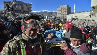 Turkish rescue workers from Kazakhstan and Turkey pull Hatice Akar from a collapsed building