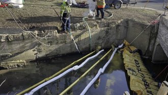Workers clean a waterway in East Palestine, Ohio