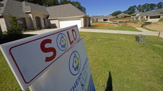 A "Sold" sign decorates the lawn of a home.