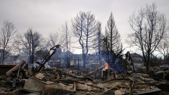 A fire burns in a home destroyed by the Marshall Wildfire.