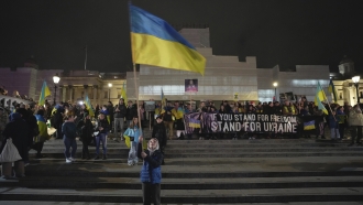 People attend a vigil at the Trafalgar Square organised by the Ukrainian and U.S. Embassies