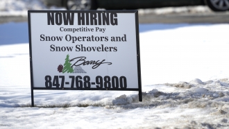 Hiring sign displayed for snow operators and snow shovelers.