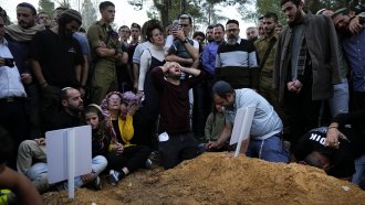 People mourn over graves of Israeli brothers who were killed Sunday.