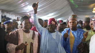 Bola Tinubu of the All Progressives Congress, center, celebrates with supporters at the party's campaign headquarters