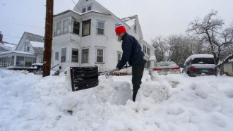 Rocio Franco shovels the snow from the open of her driveway.