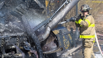 Firefighters work the scene after a tanker truck overturned on U.S. 15 in Frederick, Md.