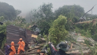 Rescuers search for victims at the site where a landslide hit a village in Indonesia