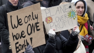 Environmental activists holding signs take part in a protest rally.