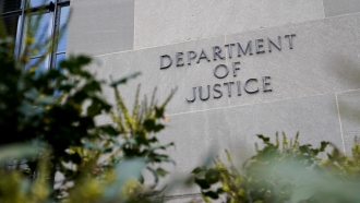 A sign marks an entrance to the Robert F. Kennedy Department of Justice Building.